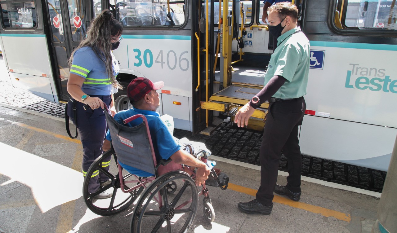 motorista auxilia cadeirante a usar o elevador de acesso ao ônibus